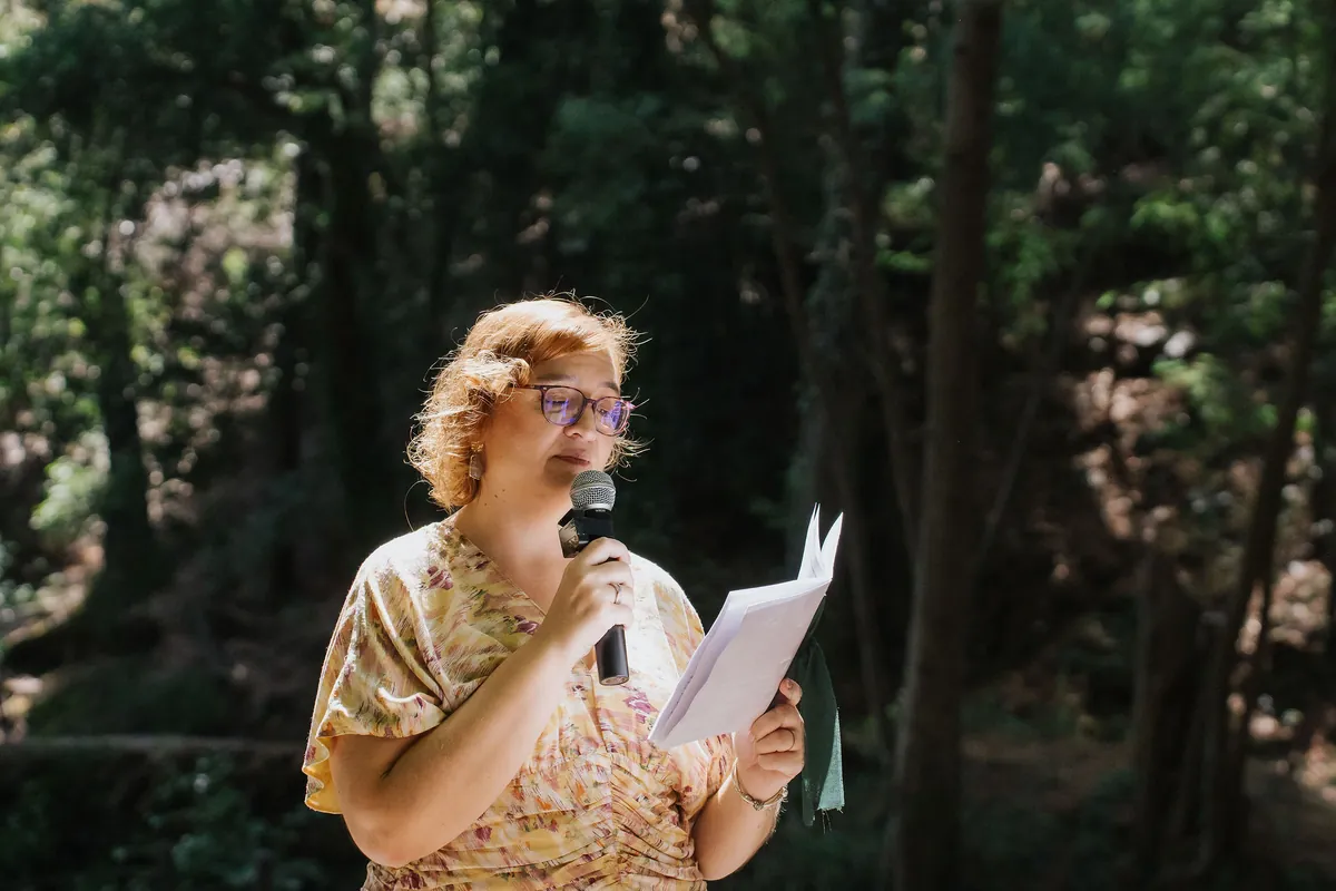 A celebrante a conduzir uma cerimónia junto ao rio